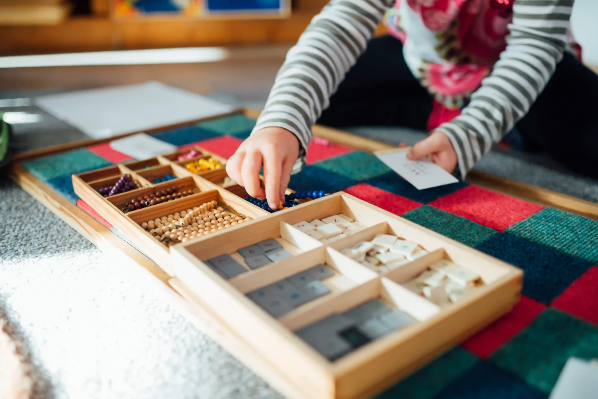 Enfant manipulant les barres rouges Montessori